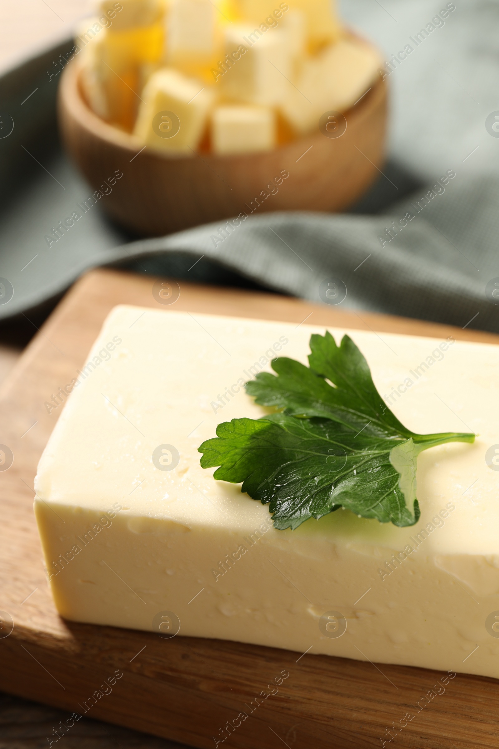 Photo of Tasty butter with parsley on wooden table, closeup