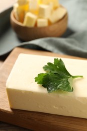 Tasty butter with parsley on wooden table, closeup