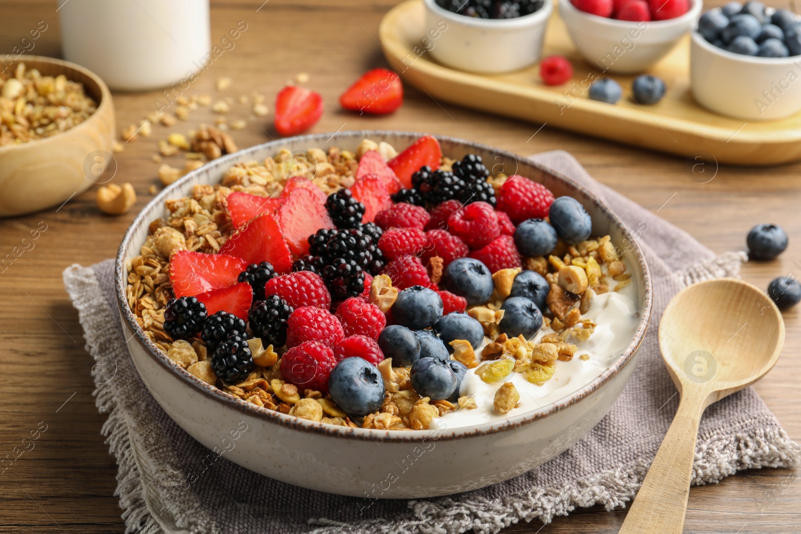 Photo of Healthy muesli served with berries on wooden table