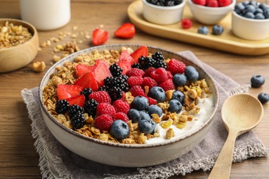 Healthy muesli served with berries on wooden table