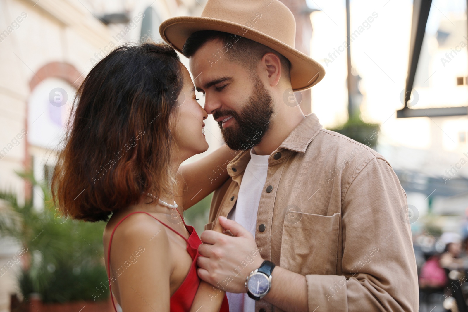 Photo of Happy young couple kissing on city street