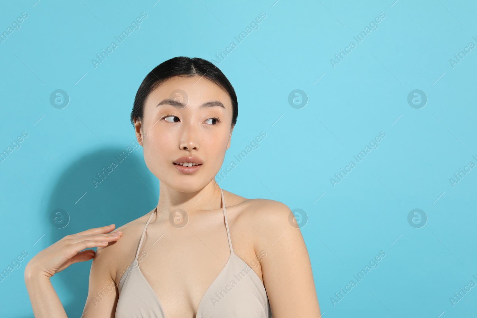 Photo of Beautiful young woman on light blue background, space for text