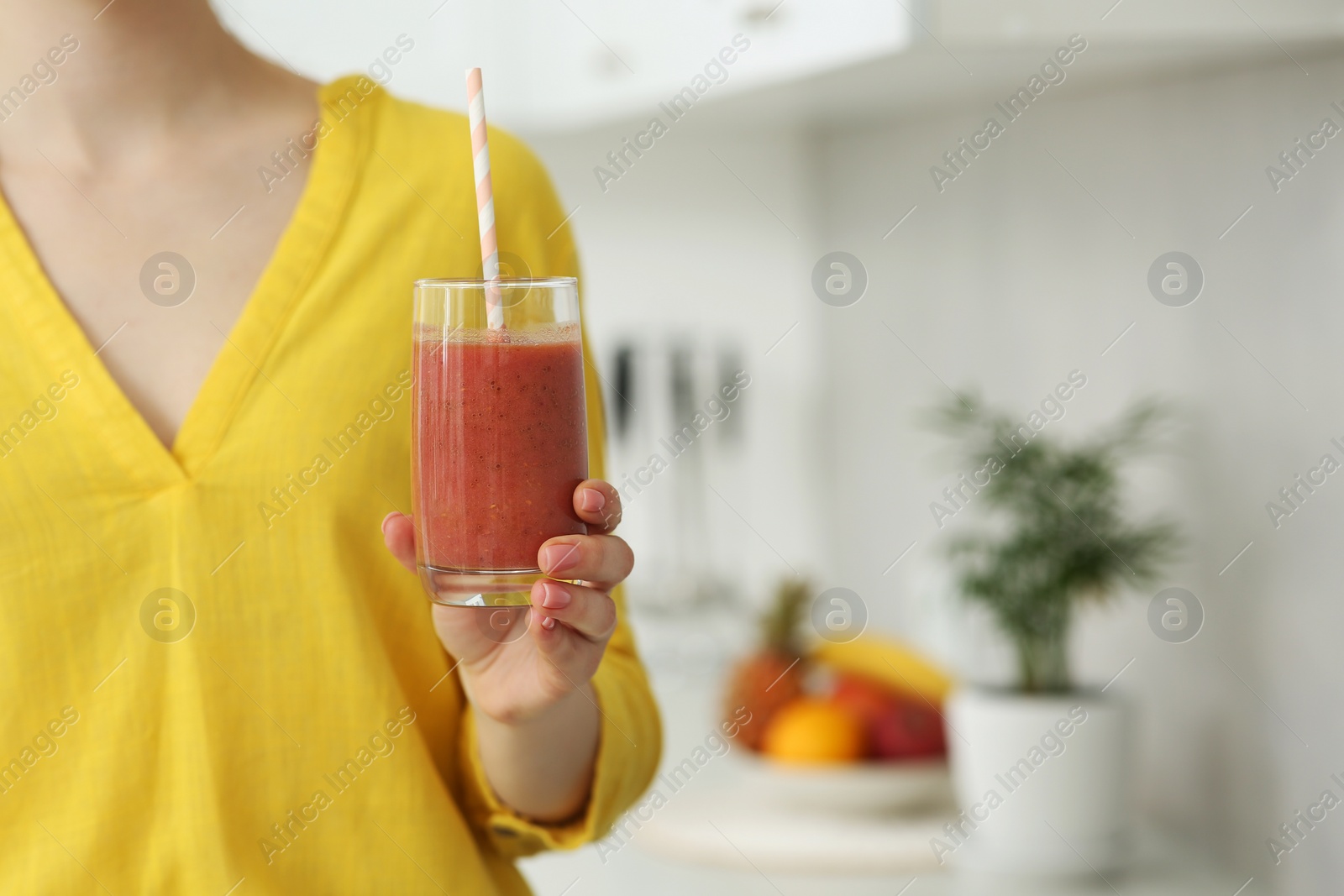 Photo of Woman with delicious smoothie in kitchen, closeup. Space for text