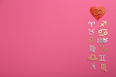Photo of Zodiac compatibility. Signs, wedding rings and red heart on pink background, flat lay. Space for text