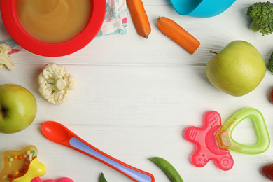 Frame of healthy baby food, ingredients and accessories on white wooden table, flat lay. Space for text