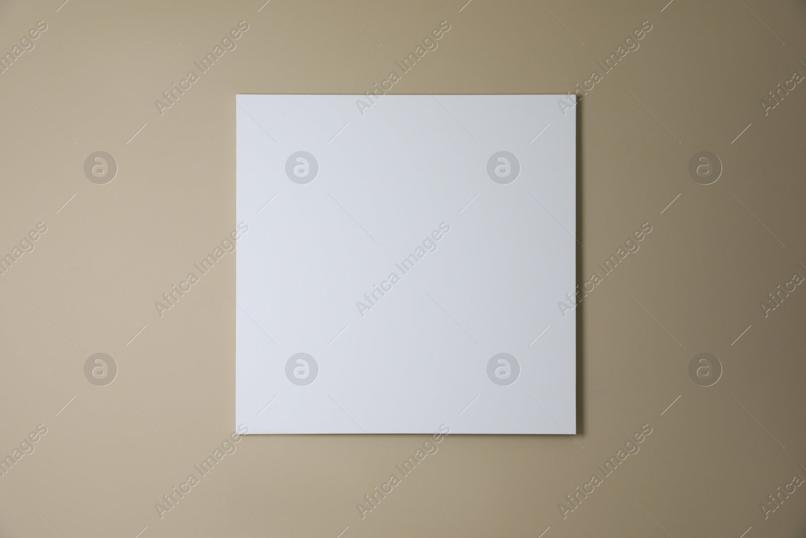 Photo of Blank canvas on beige wall. Space for design