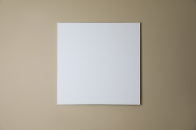 Blank canvas on beige wall. Space for design