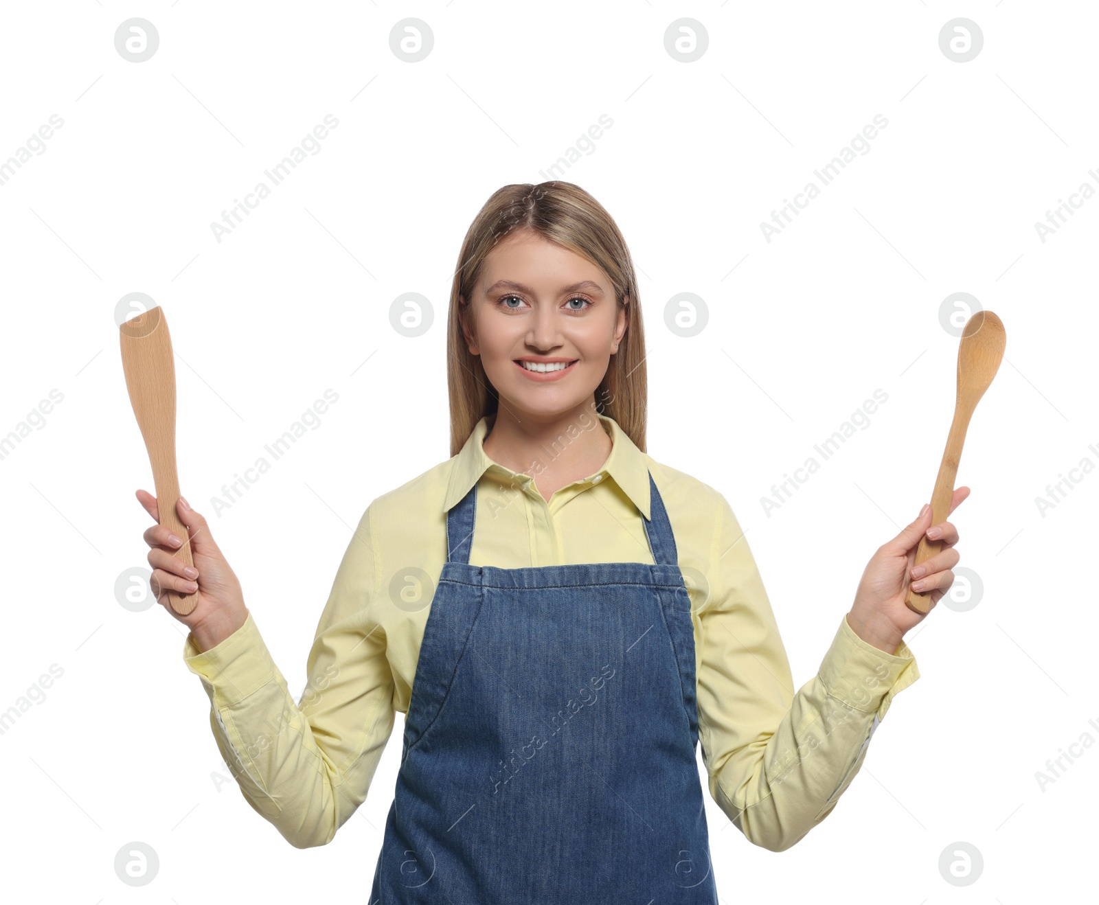 Photo of Beautiful young woman in denim apron with cooking utensils on white background