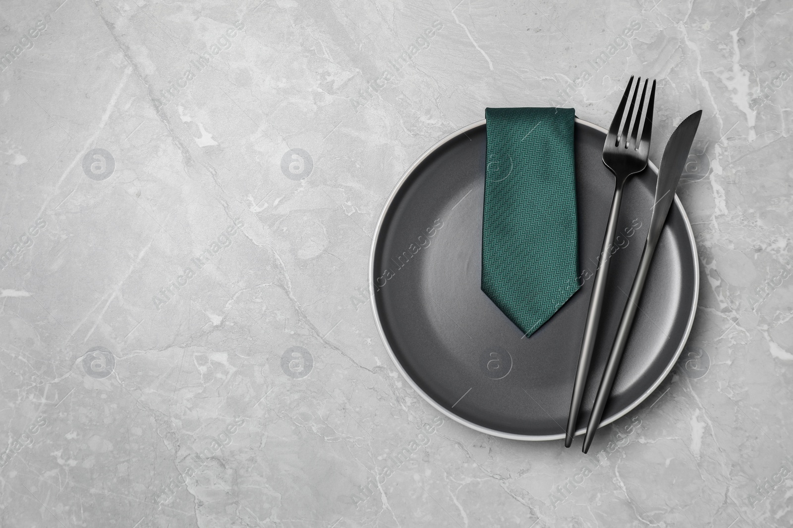 Photo of Business lunch concept. Plate, cutlery and tie on light gray marble table, flat lay with space for text