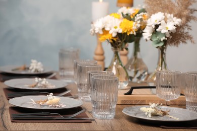 Photo of Elegant festive setting with floral decor on wooden table