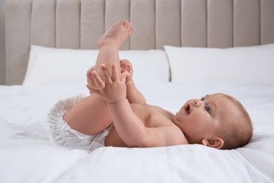 Photo of Cute baby in dry soft diaper on white bed