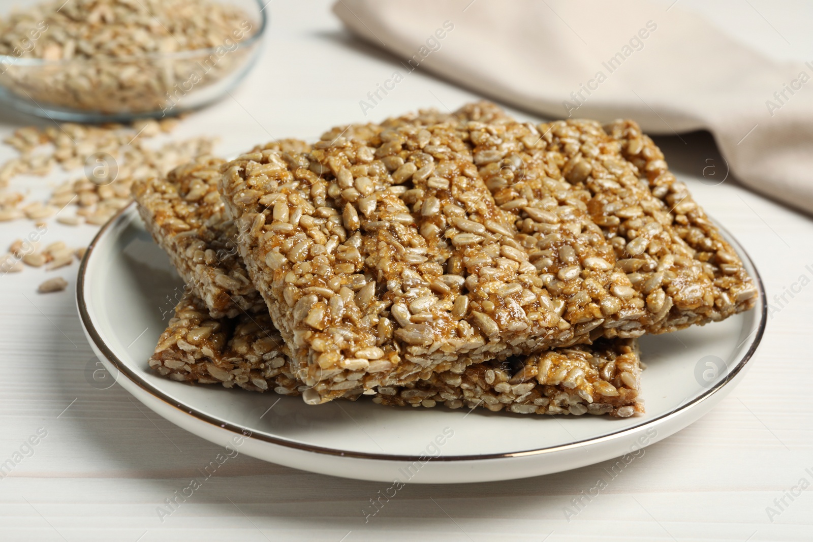 Photo of Delicious sweet kozinaki bars on white wooden table, closeup