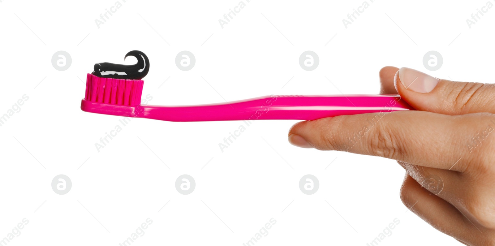 Photo of Woman holding brush with charcoal toothpaste against white background, closeup