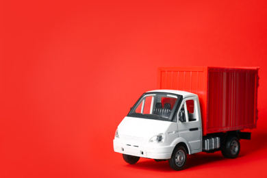 Toy truck on red background, space for text. Logistics and wholesale concept
