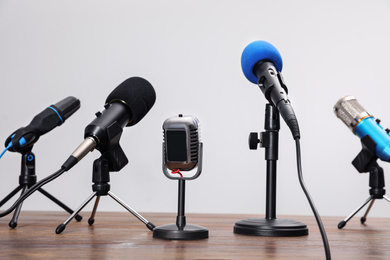 Photo of Set of different microphones on wooden table. Journalist's equipment