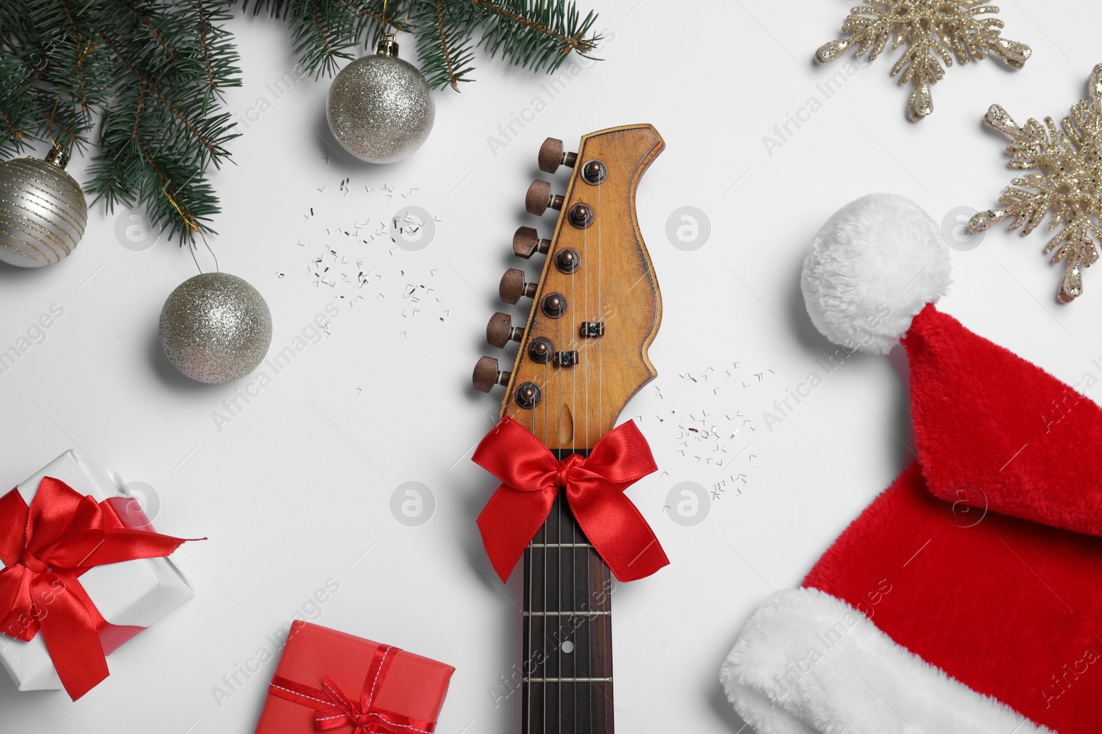 Photo of Flat lay composition with guitar and Santa hat on white background. Christmas music