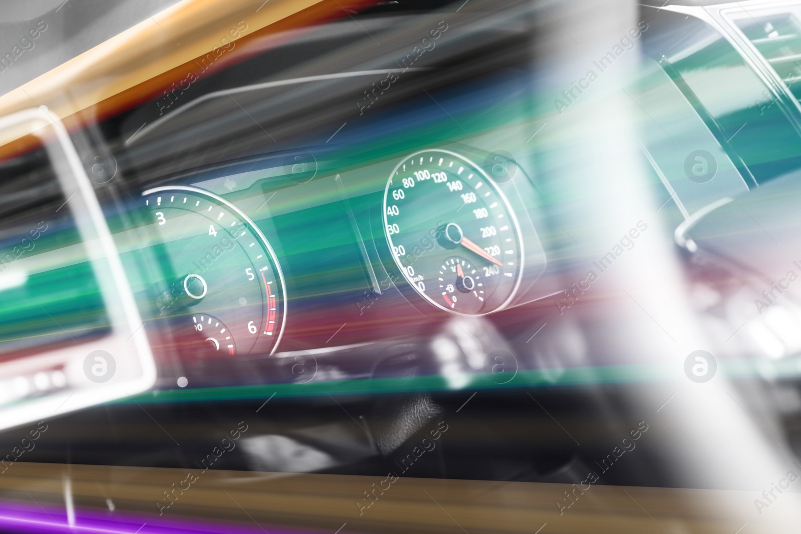 Image of Speedometer and tachometer behind steering wheel in car, motion blur effect