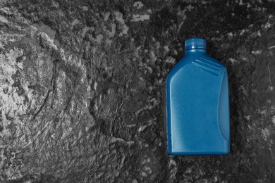 Photo of Motor oil in blue canister on black table, top view. Space for text