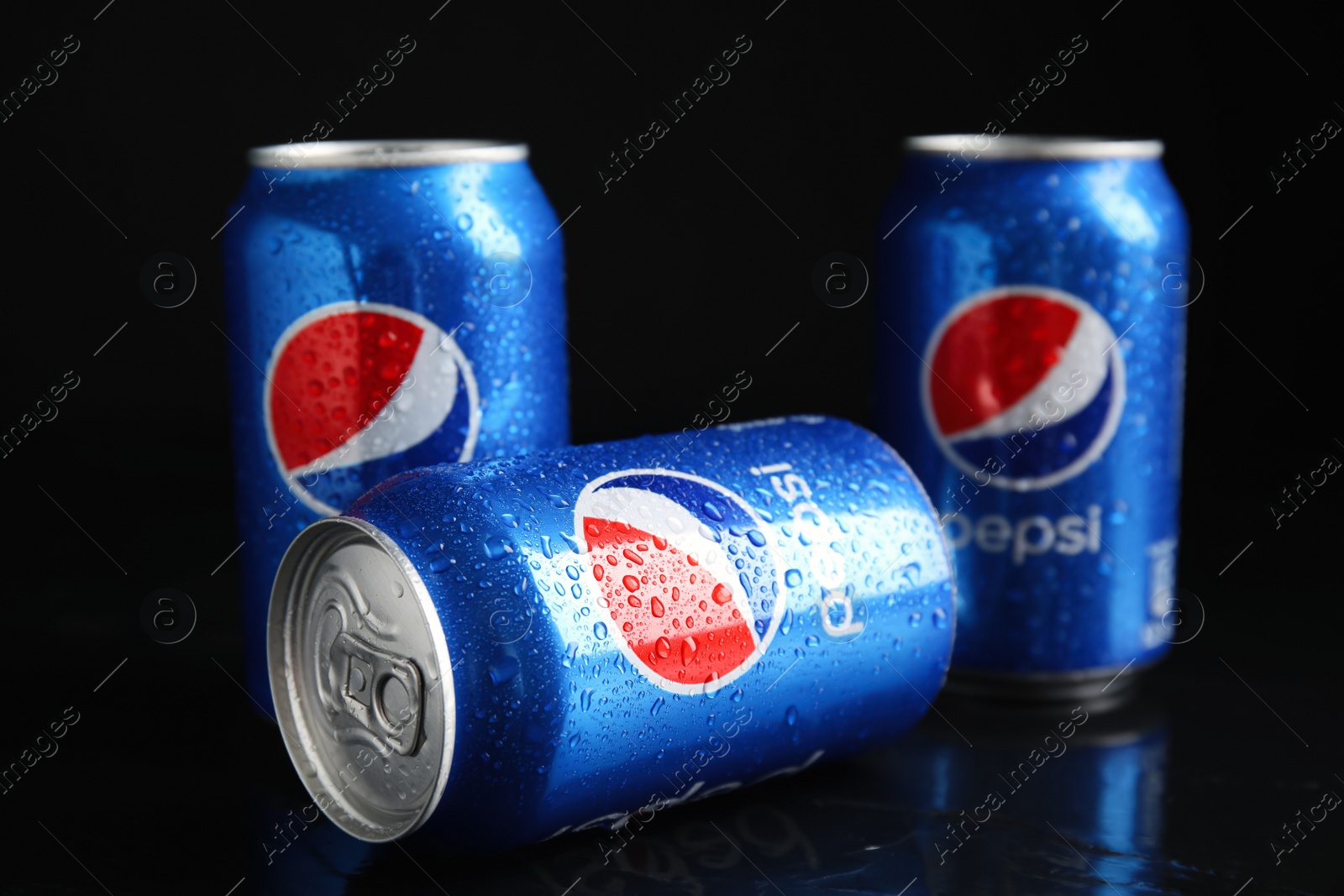 Photo of MYKOLAIV, UKRAINE - FEBRUARY 08, 2021: Cans of Pepsi with water drops on black table