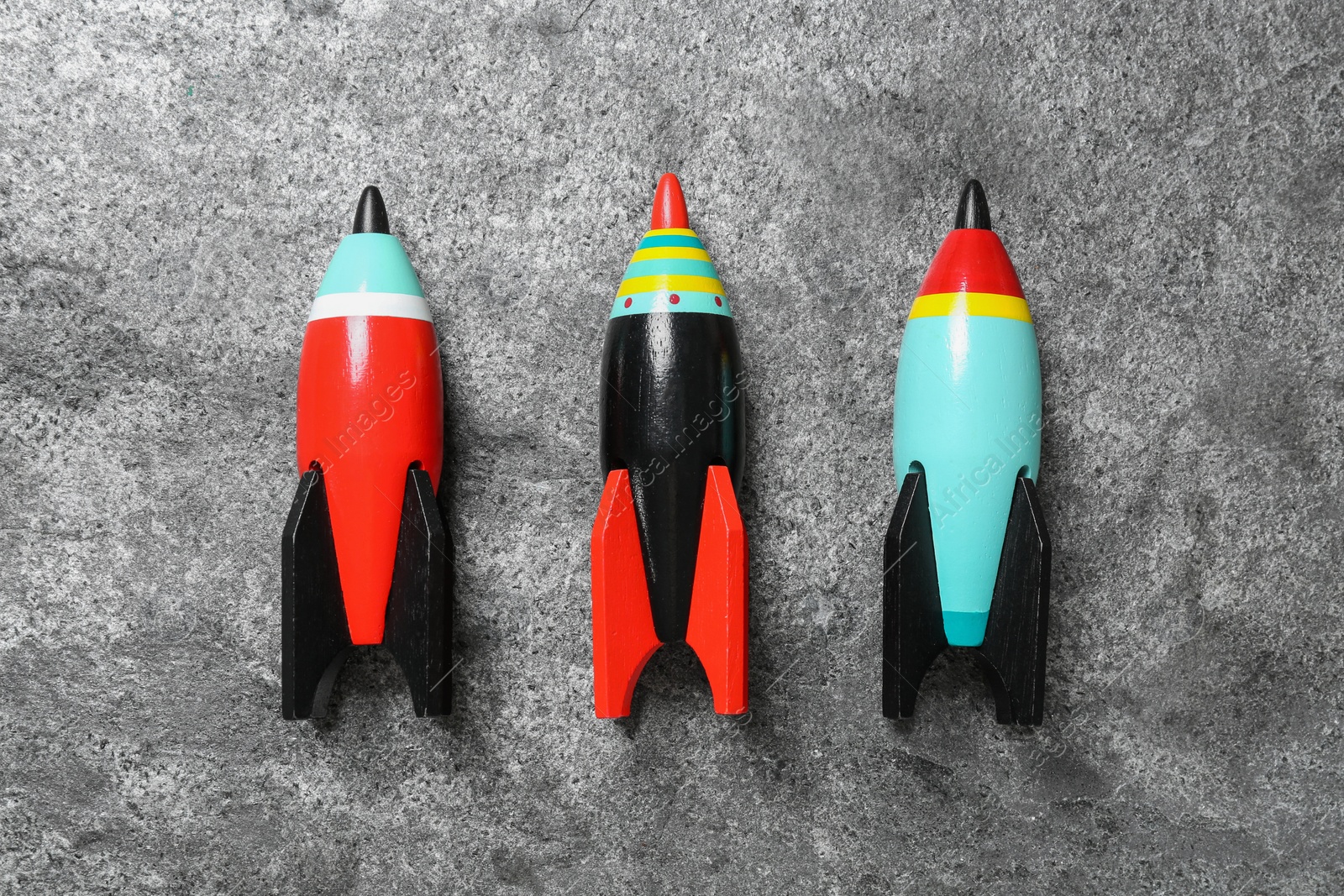 Photo of Bright color wooden rockets on grey background, flat lay