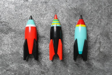 Bright color wooden rockets on grey background, flat lay