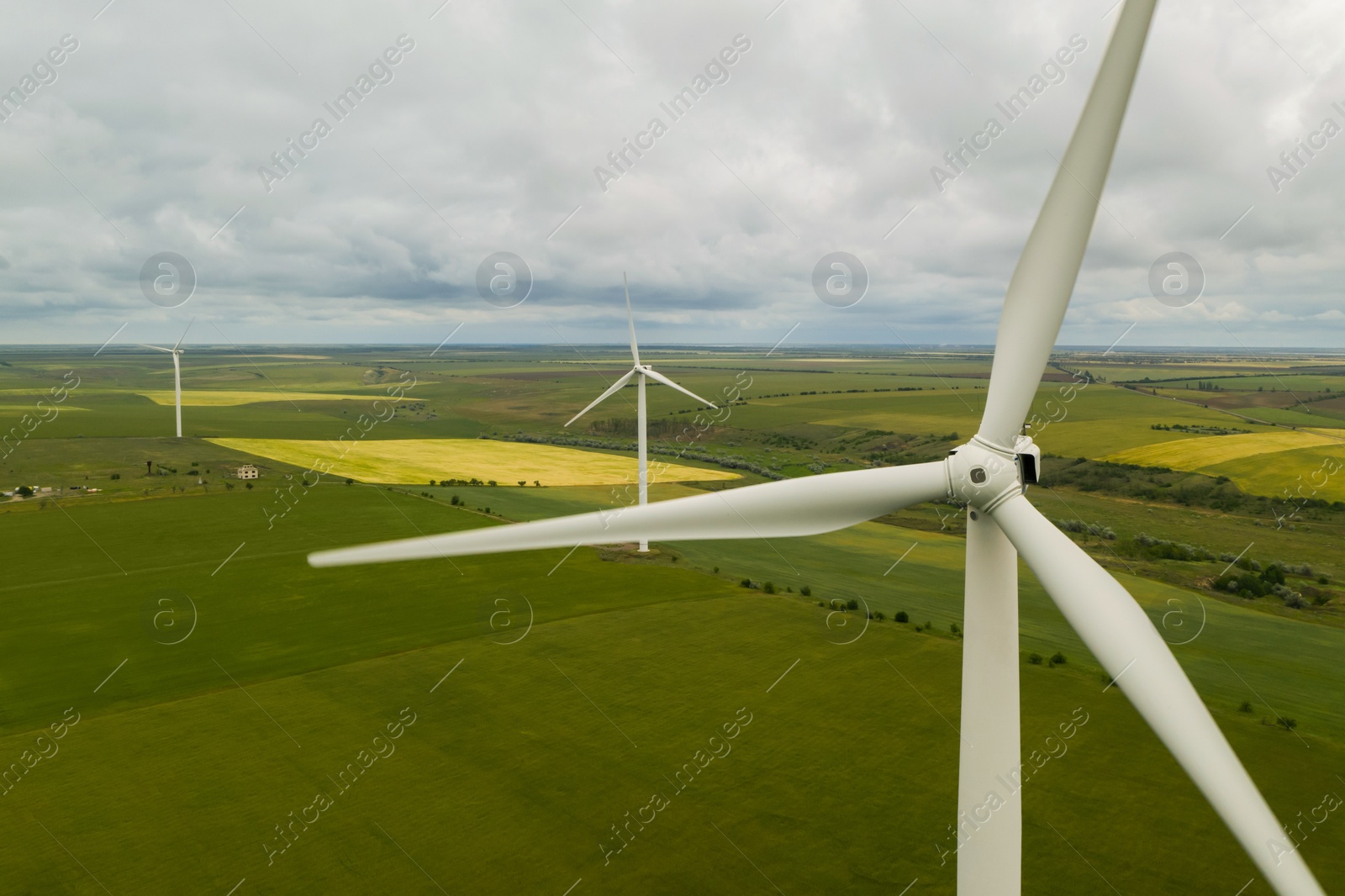 Image of Aerial view of wind turbines in field on cloudy day