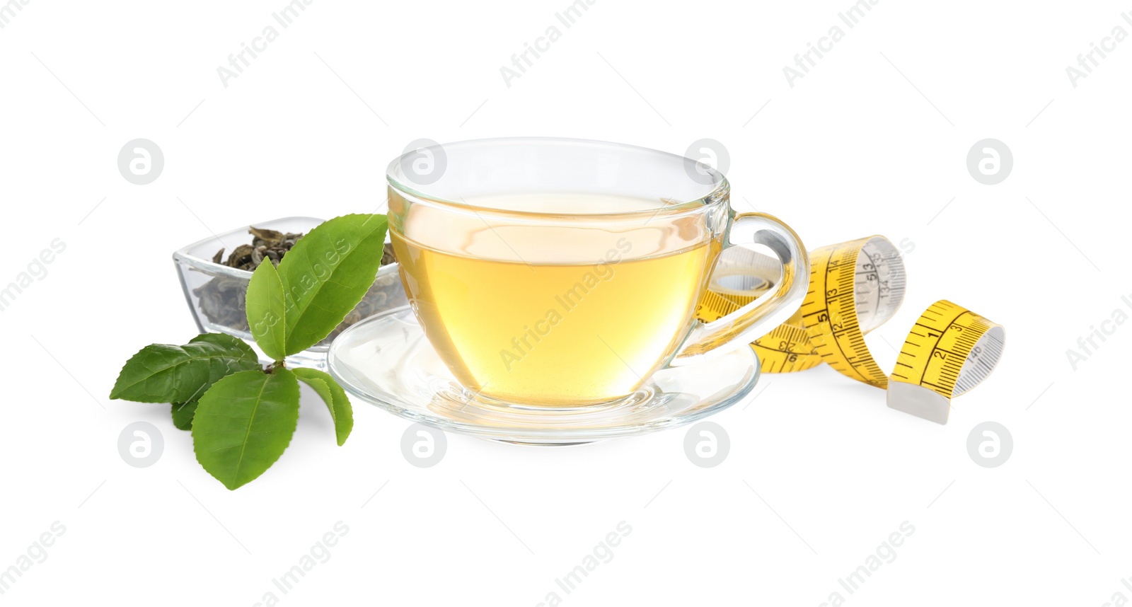 Photo of Glass cup of diet herbal tea, measuring tape, dry and fresh leaves on white background