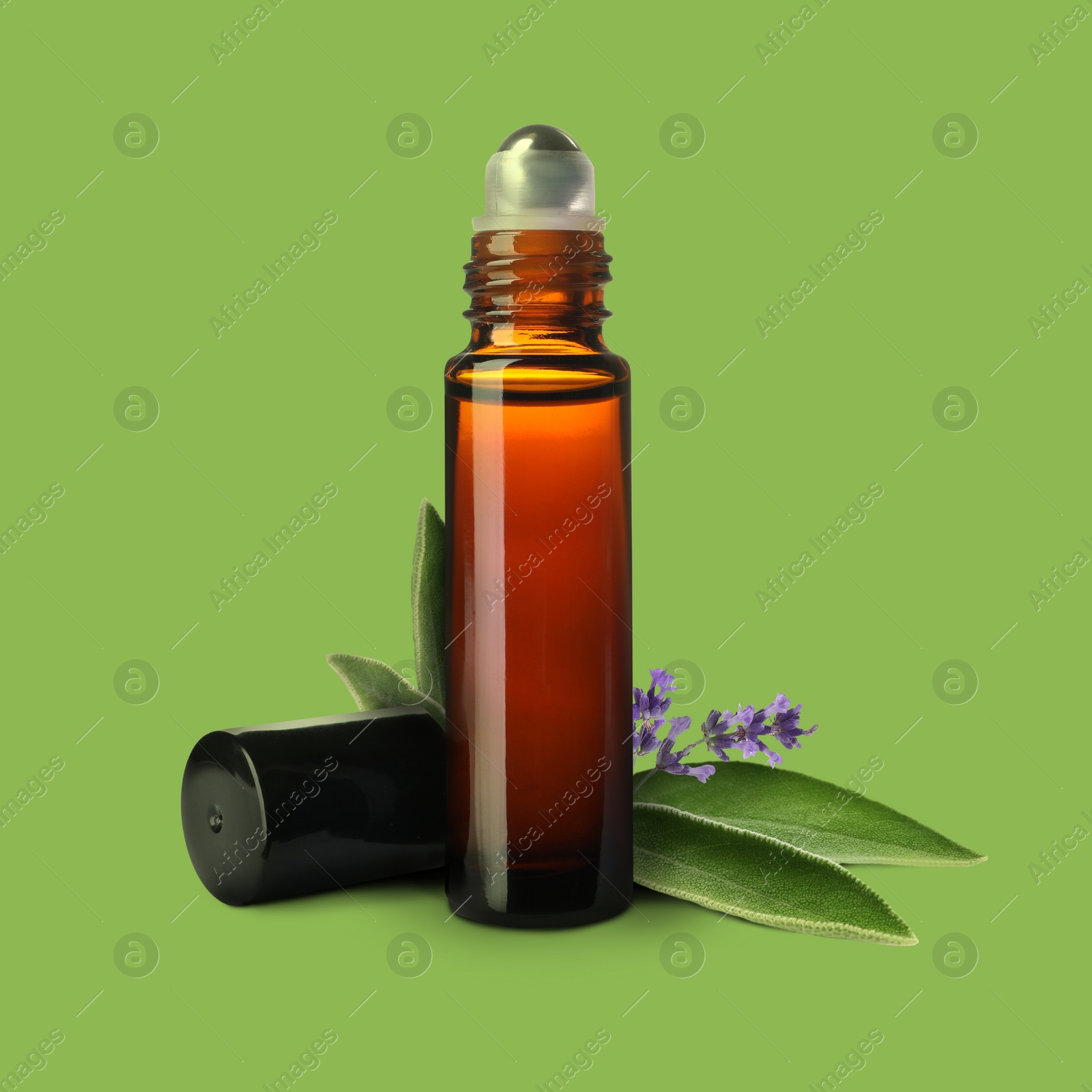 Image of Bottle of lavender sage essential oil, leaves and flowers on light green background