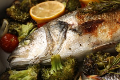 Photo of Delicious fish with vegetables and lemon, closeup