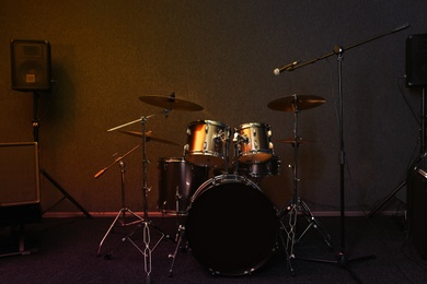 Photo of Modern drum set and microphone in recording studio
