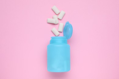 Photo of Jar with chewing gums on pink background, flat lay