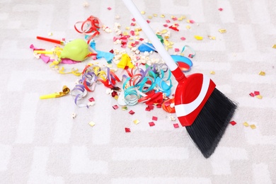 Photo of Sweeping trash after party with bristle broom indoors