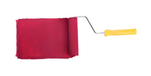 Photo of Applying burgundy paint with roller brush on white background, top view