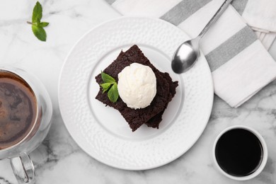 Tasty brownies with ice cream and mint served on white marble table, flat lay