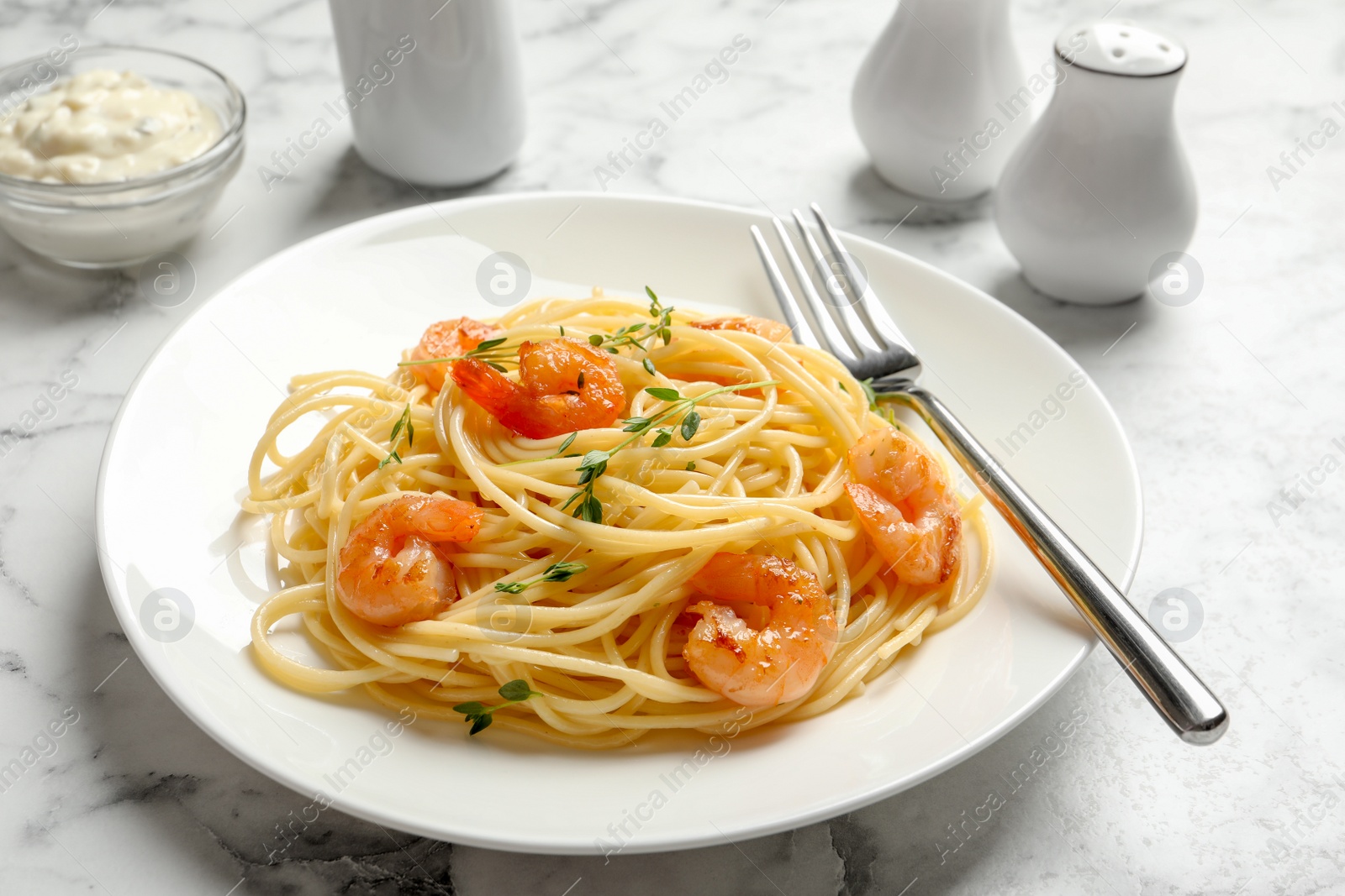 Photo of Plate with spaghetti and shrimps on table