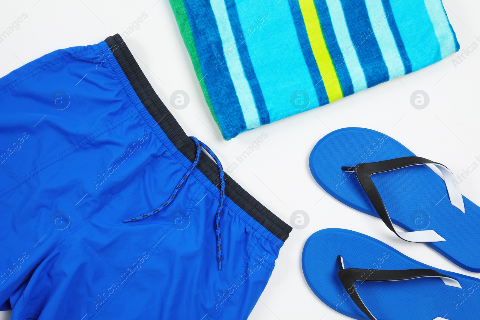 Photo of Flat lay composition with stylish male swim trunks on white background. Beach objects