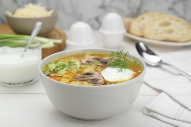 Photo of Delicious sauerkraut soup with mushrooms, dill and sour cream served on white table