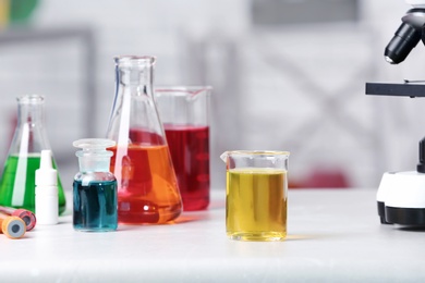 Photo of Different glassware with samples on table in chemistry laboratory