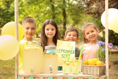 Photo of Little children at lemonade stand in park
