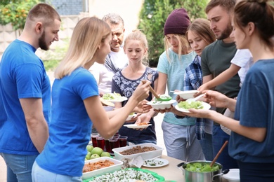 Photo of Volunteers serving food for poor people outdoors