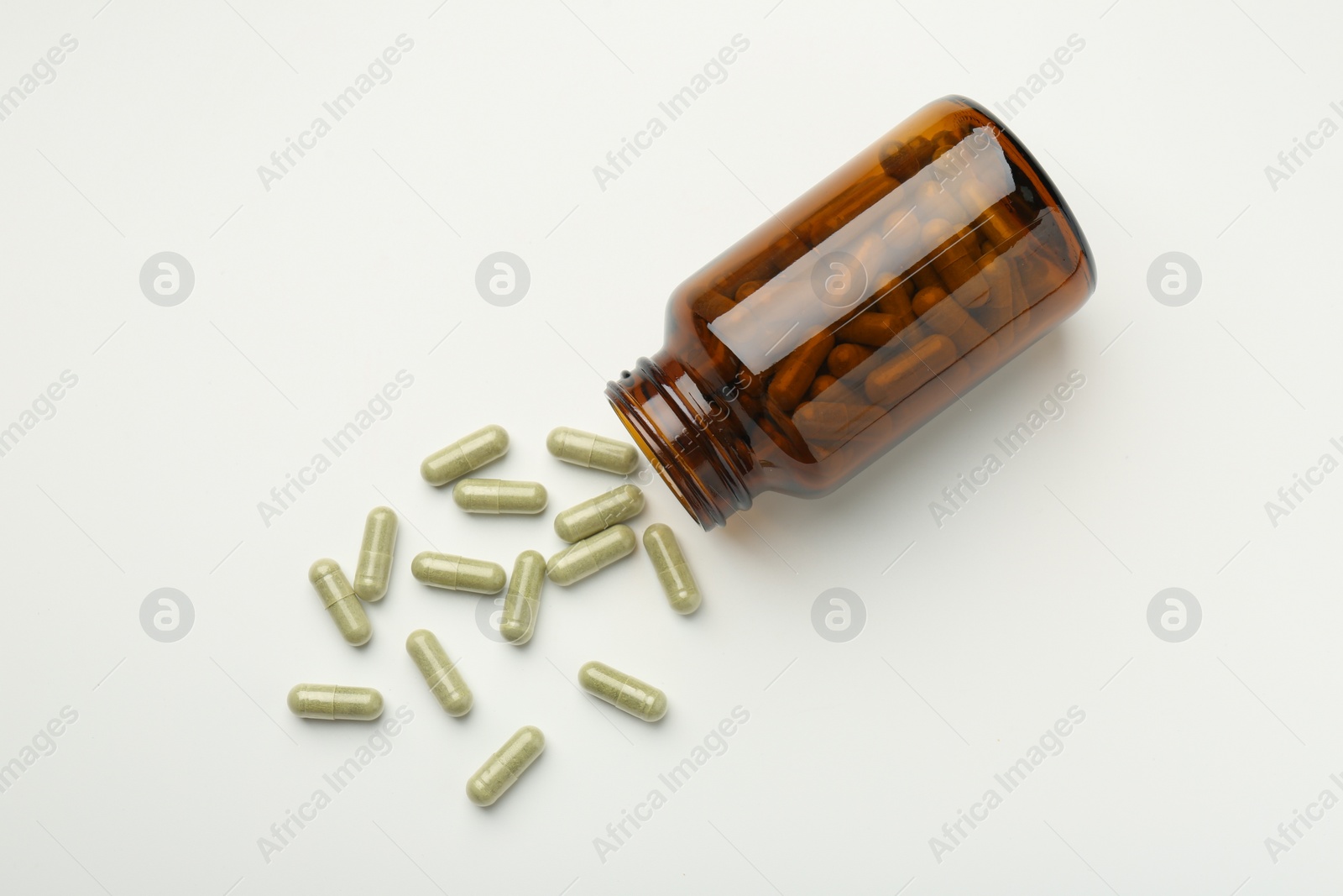 Photo of Bottle and vitamin capsules on white background, flat lay