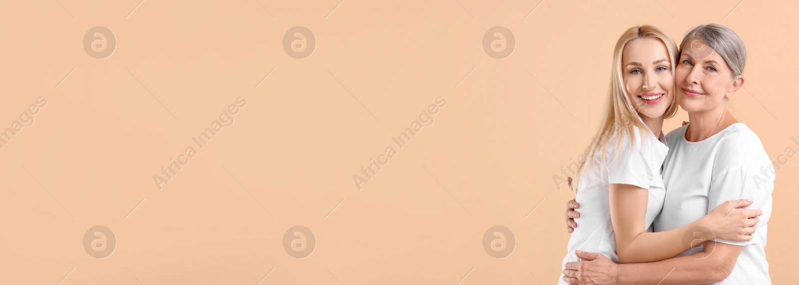 Image of Happy mother and daughter on beige background, space for text. Banner design