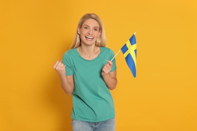 Photo of Emotional woman with flag of Sweden on yellow background