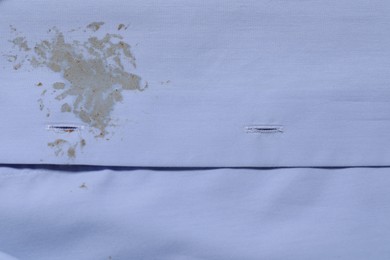 Photo of Closeup view of light blue shirt with stain