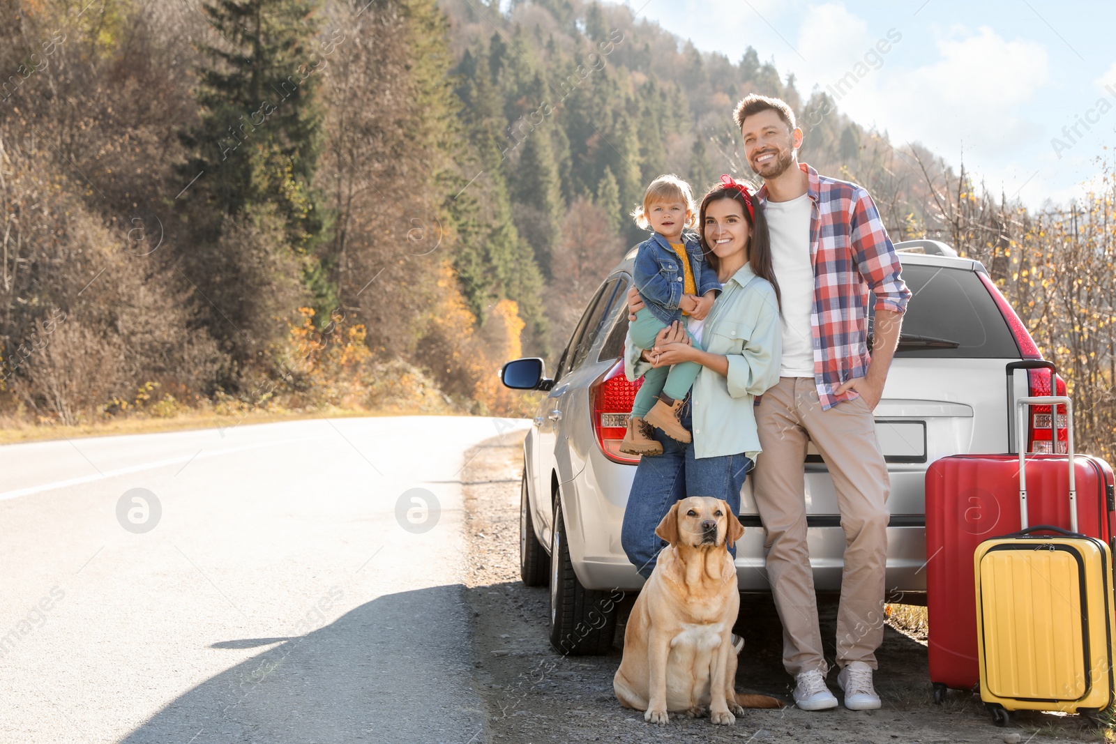 Photo of Parents, their daughter and dog near car outdoors, space for text. Family traveling with pet