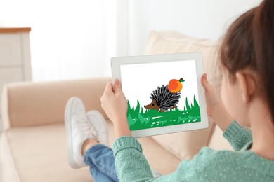 Little girl holding tablet with cute drawing at home. Child art