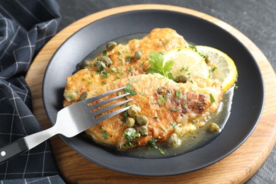 Delicious chicken piccata served on black table