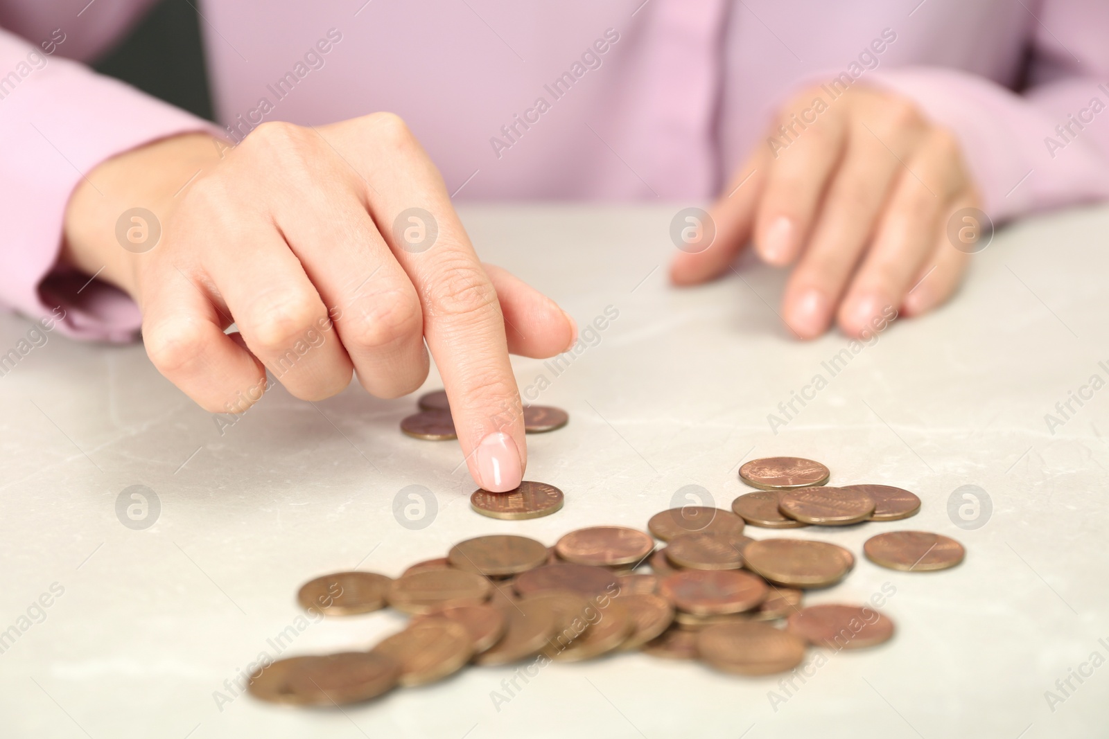 Photo of Woman counting coins at light table, closeup