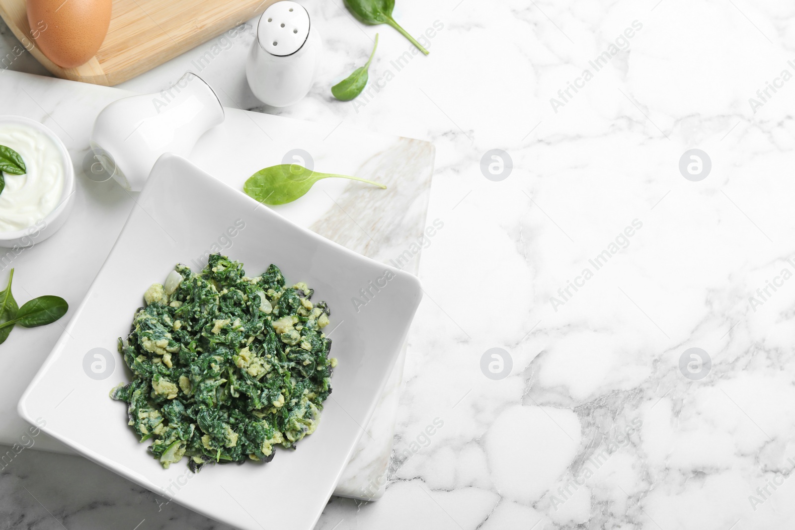 Photo of Flat lay composition with tasty spinach and space for text on white marble table. Healthy food