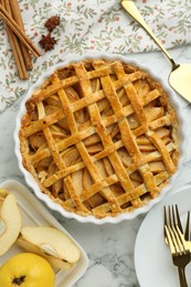 Photo of Tasty homemade quince pie served on white marble table, flat lay